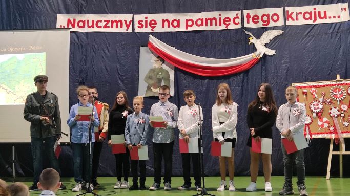 Zdjcie przedstawia uczniw stojcych podczas recytowania na uroczystej akademii z okazji Narodowego wita Niepodlegoci.    