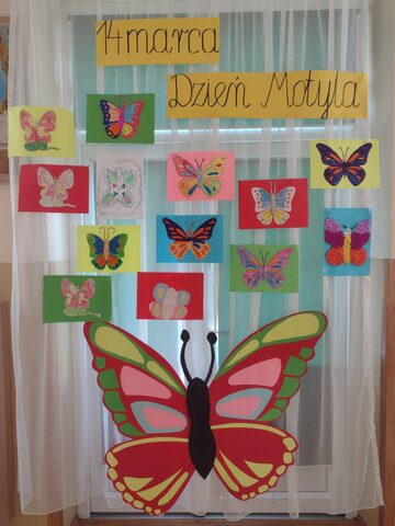  na tablicy wywieszone s prace dzieci przedstawiajce motyle, na dole duy kolorowy motyl