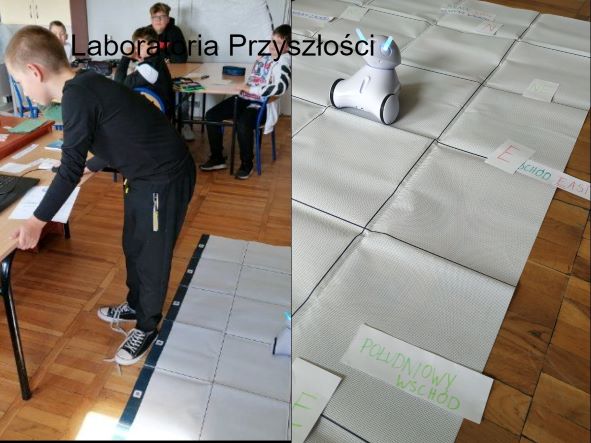 ucze stoi przy komputerze obok plansza z robotem